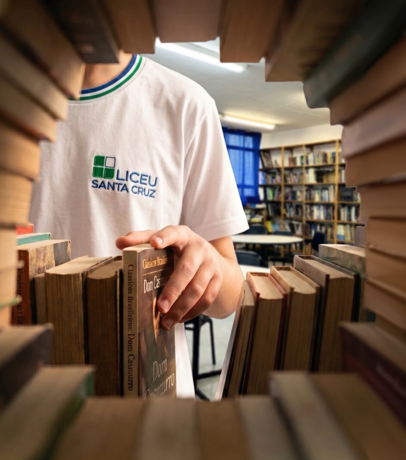 Aluno do Liceu Santa Cruz entre livros da biblioteca